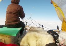 Persona en una tienda de campaña sobre un trineo de nieve impulsado por una cometa de viento