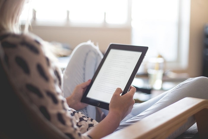 A girl reading something on a kindle.