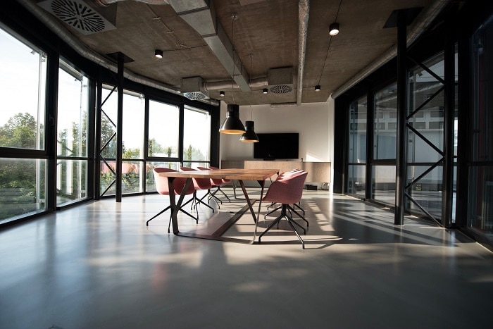 Espacio diáfano con mesa de reuniones y ventanas grandes