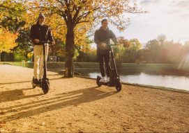 Man and woman riding and thinking about how eco-friendly are electric scooters.