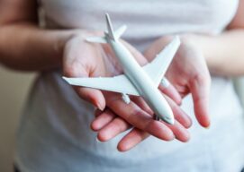 Mujer sosteniendo un avión en miniatura